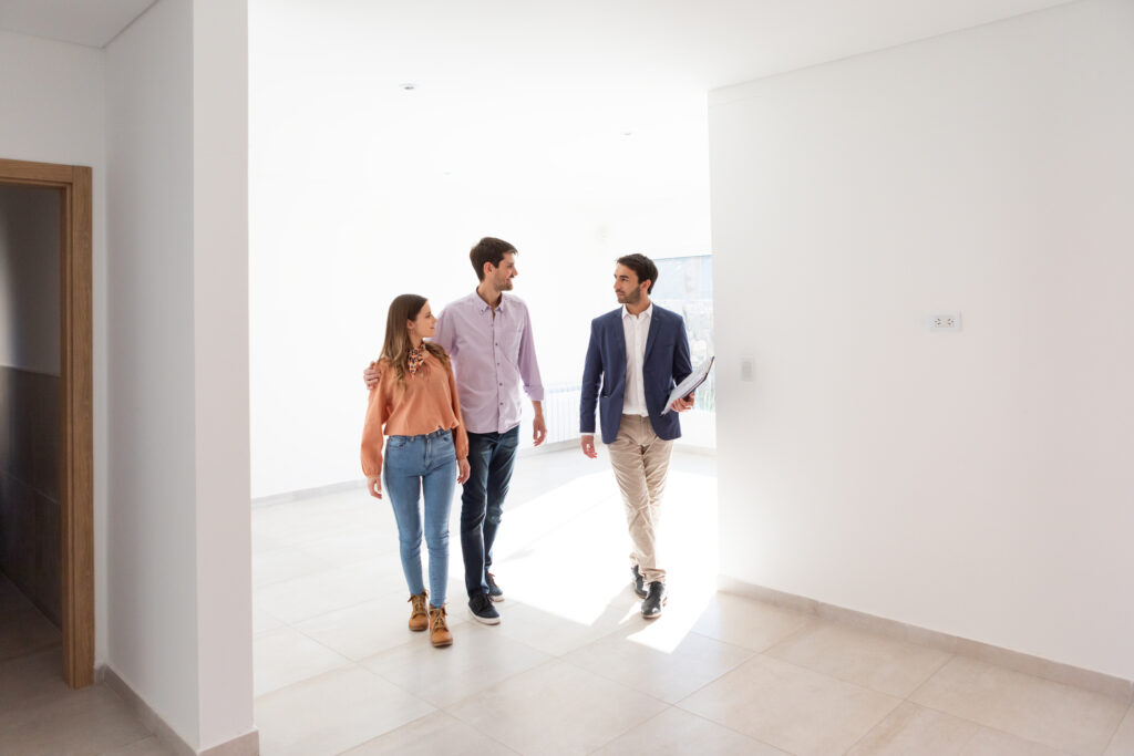 Pareja con agente inmobiliario en un departamento